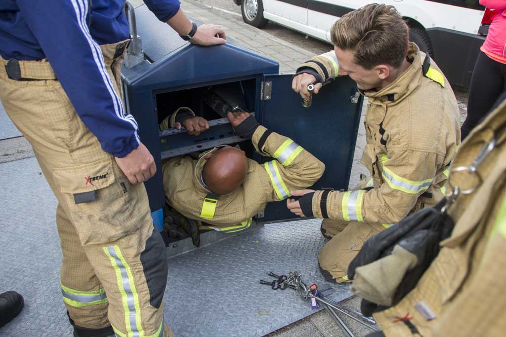 Brandweerman klimt in ondergrondse container voor verloren pinpas