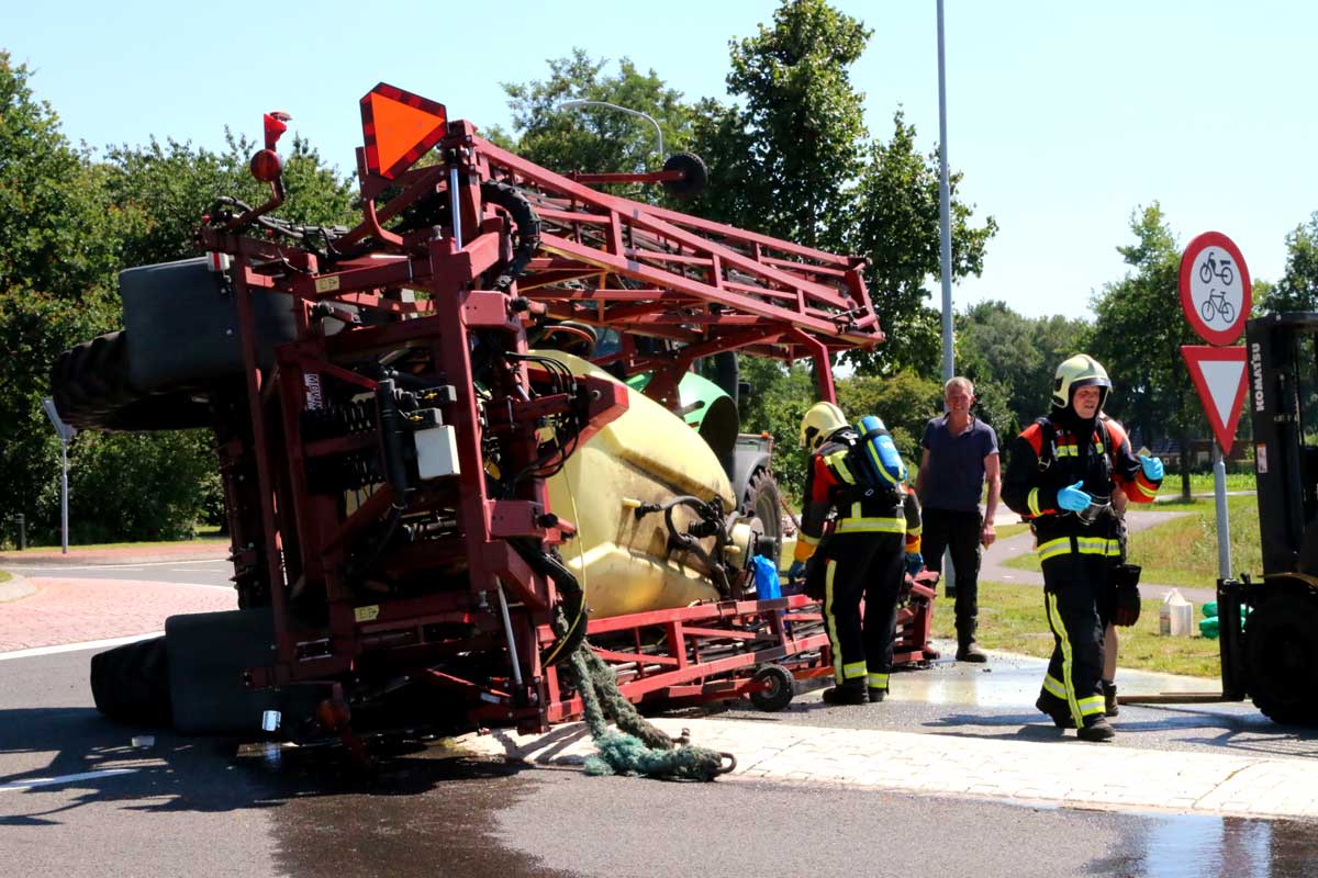 Landbouwtrekker met spuitmachine gekanteld