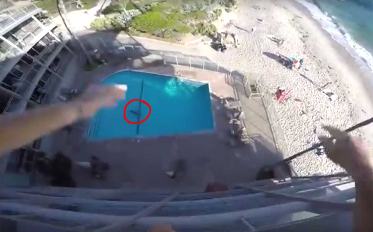 Man springt met actiecamera op hoofd van hoteldak in zwembad
