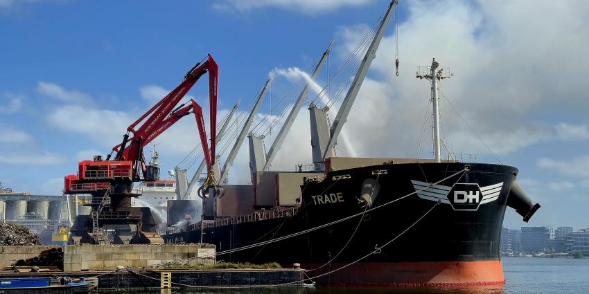 Kranen halen brandend schroot uit het schip