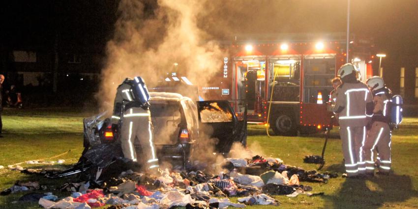 Auto vol met kleding in brand