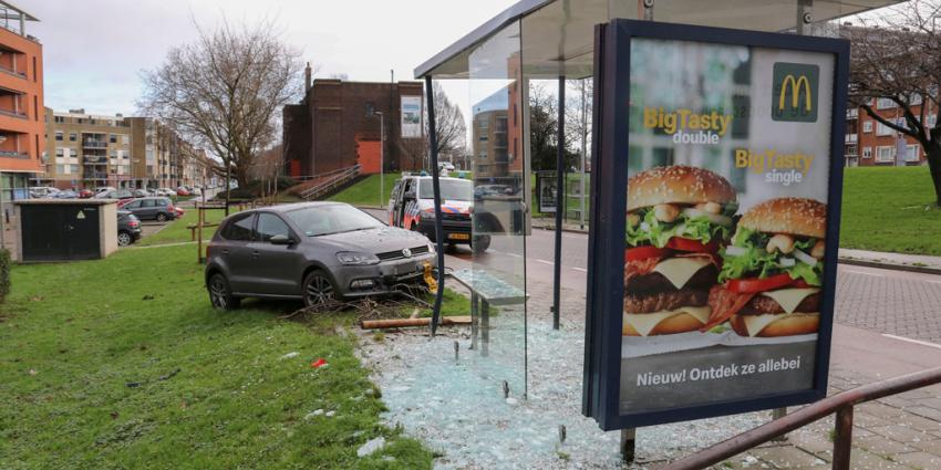 Auto via boom tegen bushokje