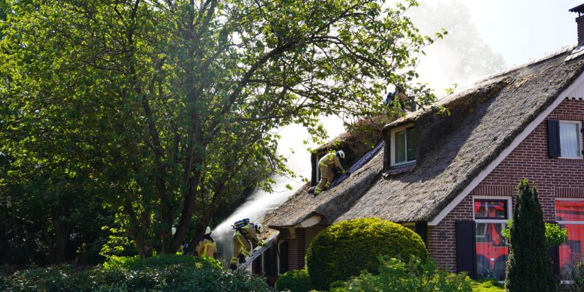 Brandweermannen halen rieten dak uit