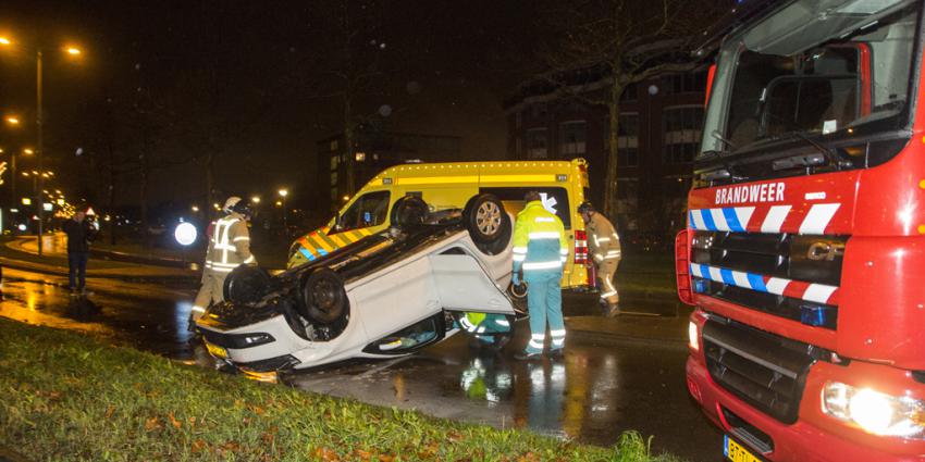 Bekneld in over de kop geslagen auto