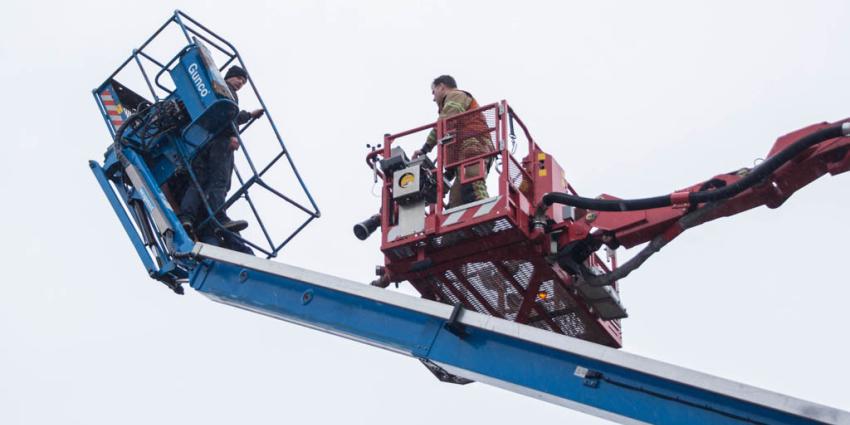 Mannen vast in gekantelde hoogwerker