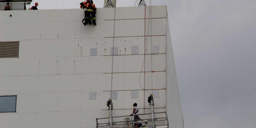 Glazenwasser op eenzame hoogte vast in bakje op 12e etage