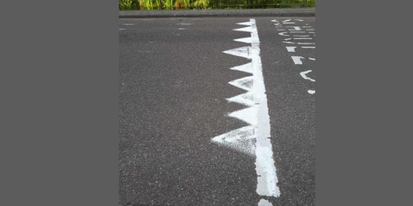 Man is hardrijders zat en kalkt haaientanden op wegdek