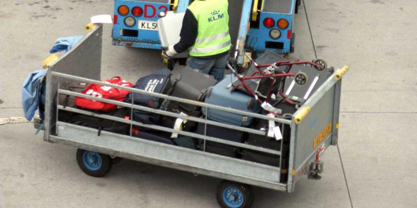 Medewerker KLM bij bagageband