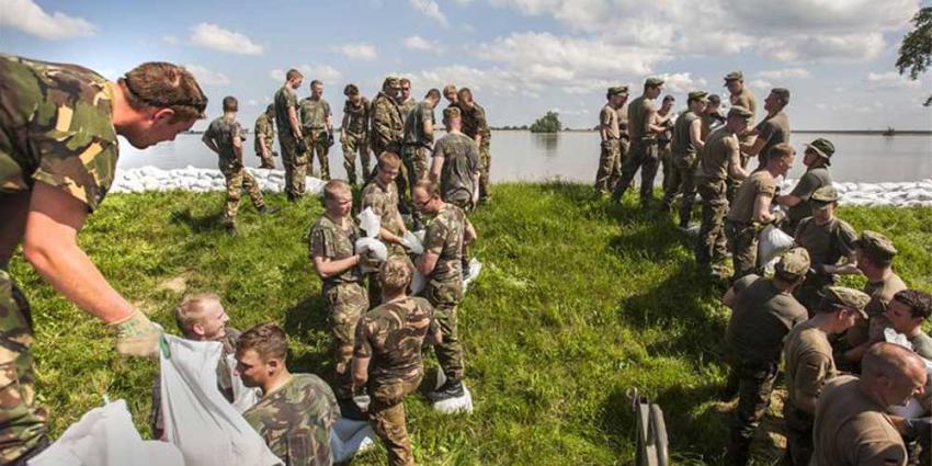 Foto van militairen die dijk verstevigen | Min. Defensie