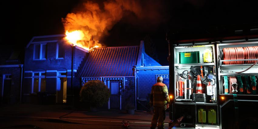 Vlammen slaan uit dak van woning