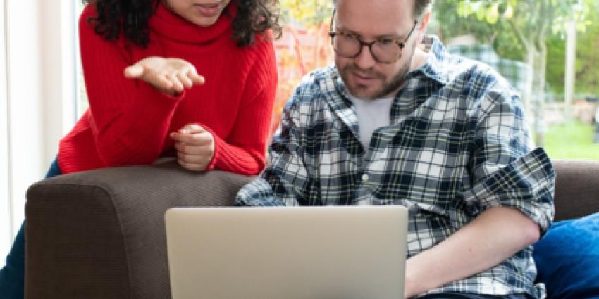 Man en vrouw kijken op laptop