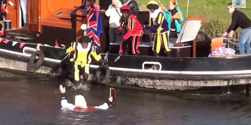 Sinterklaas door Zwarte Piet van de boot geduwd
