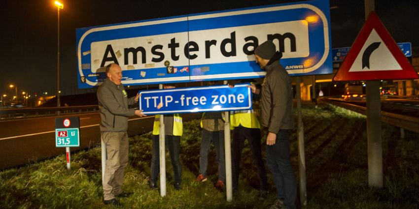 Actievoerders plaatsen verkeersbord 'TTIP free zone'