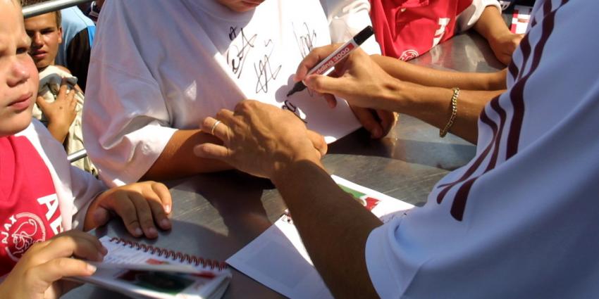 Foto van ajacied die handtekening zet op shirt | Archief EHF