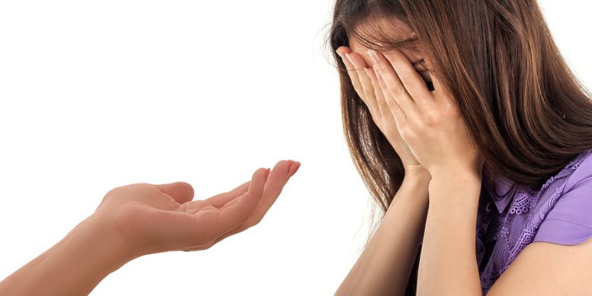 Uitgestoken hand naar huilende vrouw