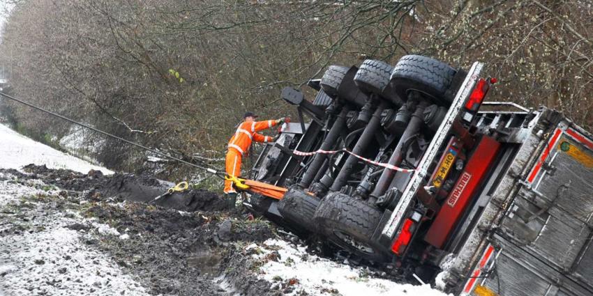 Truck met oplegger glijdt van de weg sloot in