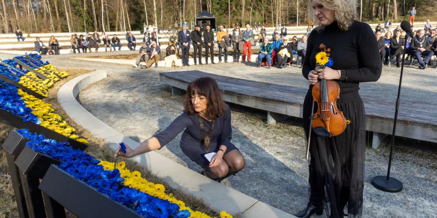 De Oekraïense Iryna Savenko en de Russische Anastasia Kozlova steken de laatste bloemen in het vredesmonument.