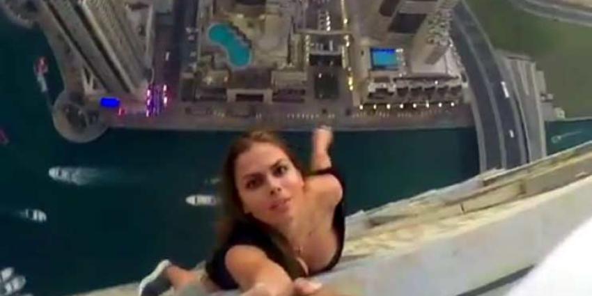 Topmodel Viki Odintcova hangt aan mannenarm op bizarre hoogte