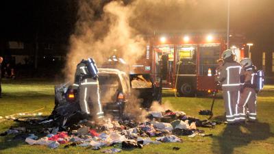 Auto vol met kleding in brand
