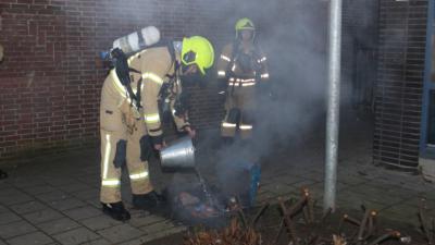 Brandweer blust brand met emmer