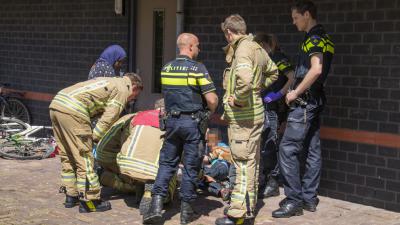 Jongetje bekneld met voet tussen trapper