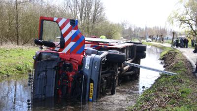 Brandweerwagen op zijn kant in het water