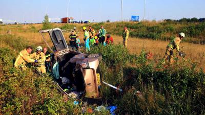 Vrouw met auto van talud snelweg A58 bij Eindhoven