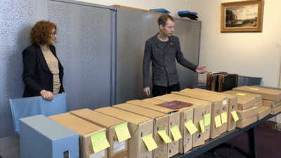 Spoorwegmuseumconservator Evelien Pieterse (l) overhandigt het archief aan Victor Lansink van Het Utrechts Archief