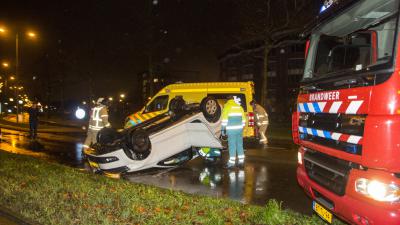 Bekneld in over de kop geslagen auto