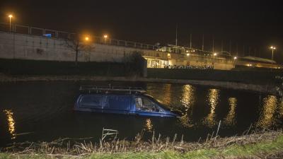 Busje rijdt vijver in