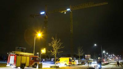 Man klimt in hijskraan op bouwterrein in Den Bosch