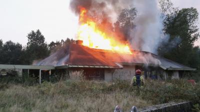 Vlammen slaan uit dak van woning