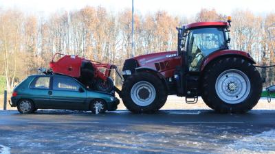 Auto duikt onder grasmaaier van landbouwvoertuig