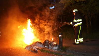 Stapels oud papier en kunststof afzetpalen in brand in Boxtel