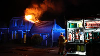 Vlammen slaan uit dak van woning