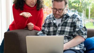 Man en vrouw kijken op laptop