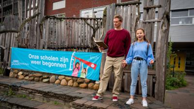 Justin Samgar en scholier Anna dragen het gedicht “Onze scholen zijn weer begonnen” voor bij basisschool de Hasselbraam in Amsterdam.