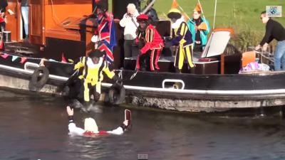 Sinterklaas door Zwarte Piet van de boot geduwd