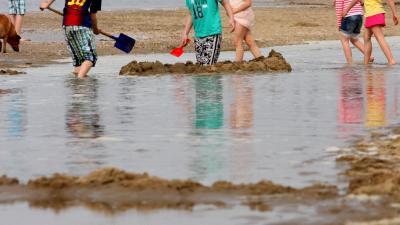 Foto van met water spelende kinderen op strand | Archief EHF